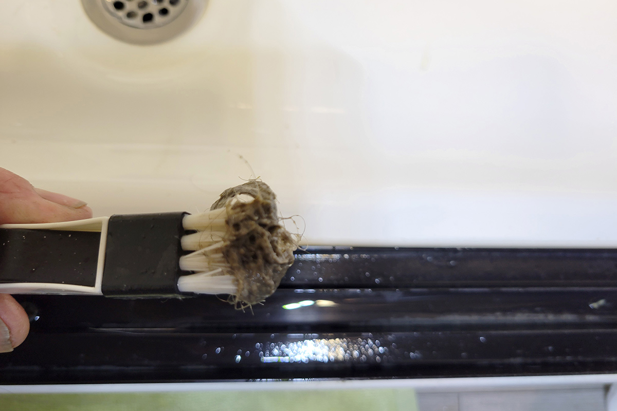 close view of the hair and debris picked up by the Magic Window Track Cleaner brush