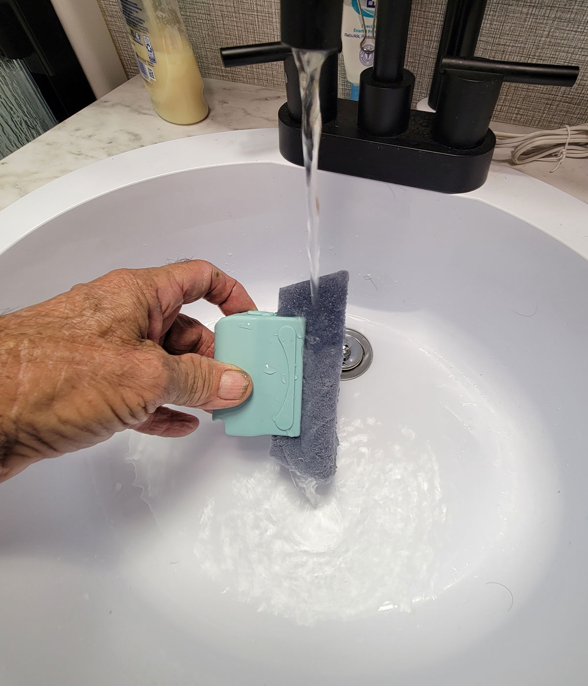 one of the Magic Window Track Cleaner scrubbing pads is moistened with running water