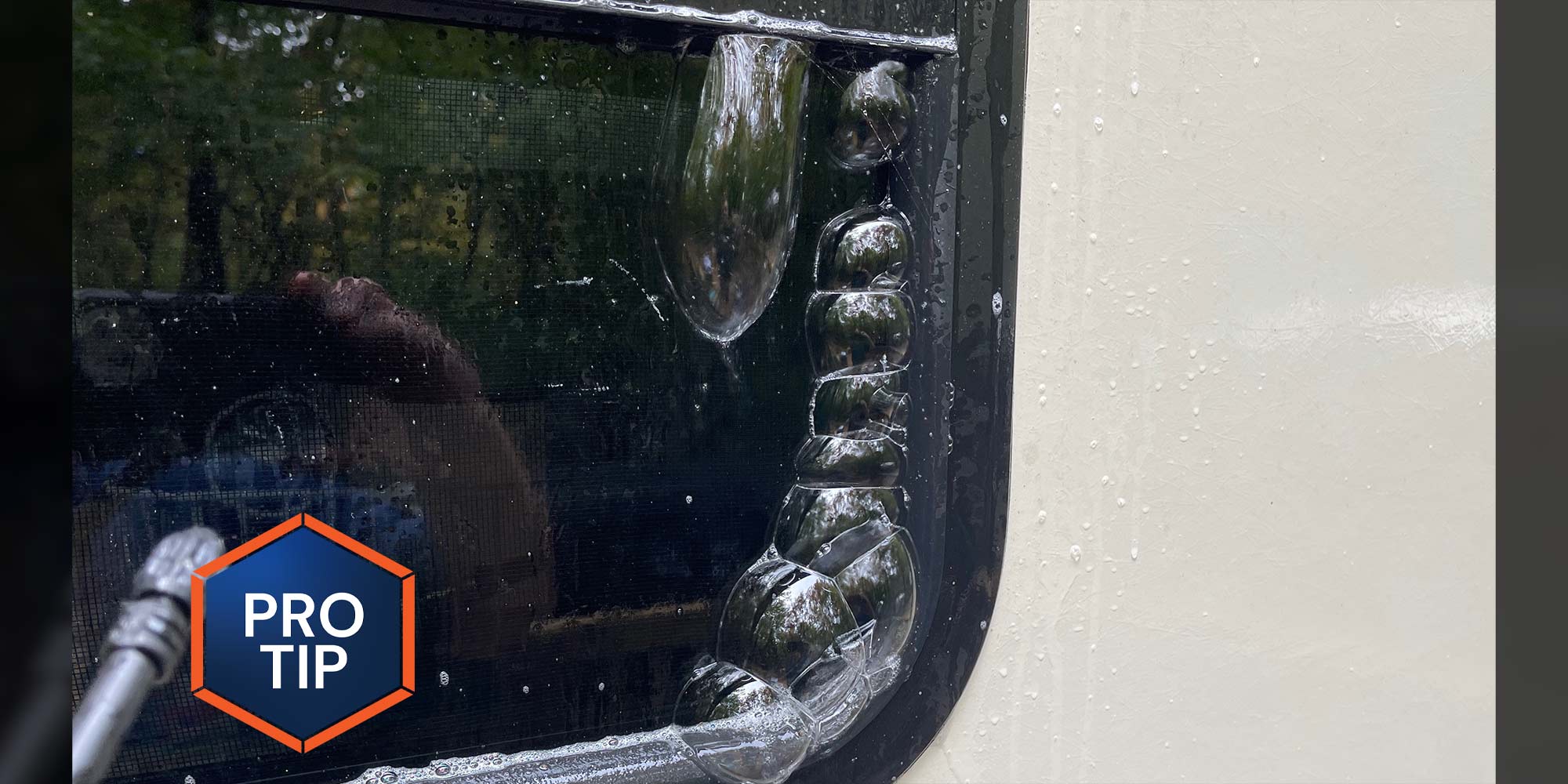 close external view of an RV window with bubbles forming along the seal between the window and its gasket