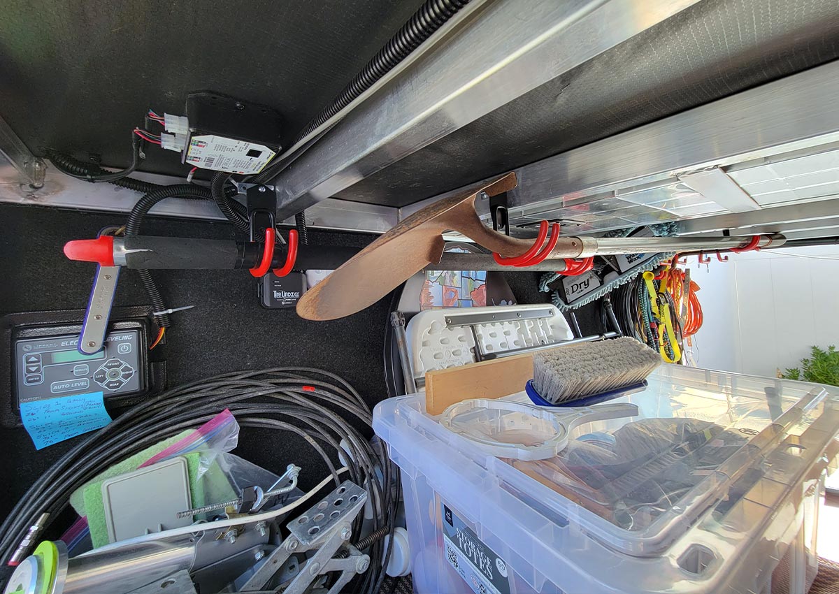 full view of a long handle broom and a shovel being held by TORACK hooks connected to L-brackets