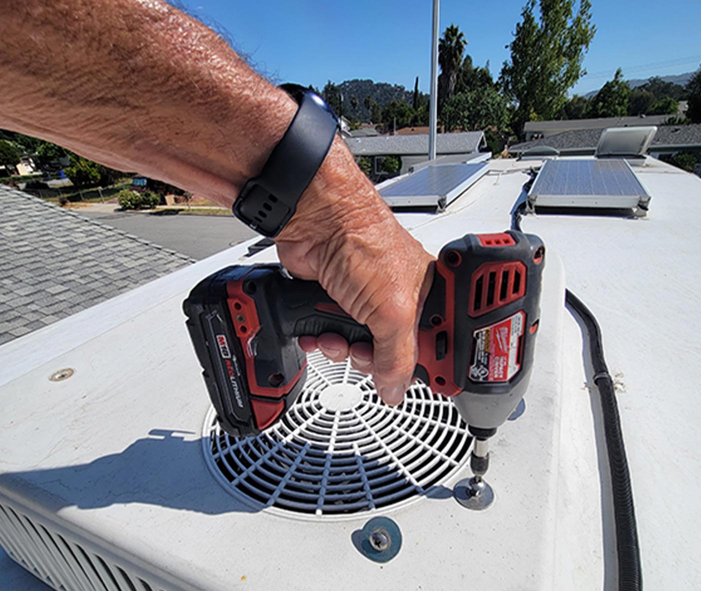 four bolts are removed from the top of the air-conditioner shroud using a drill gun