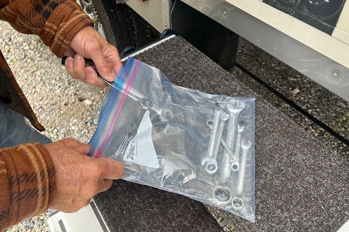 hands place wrenches of different sizes into a heavy duty Ziplock bag