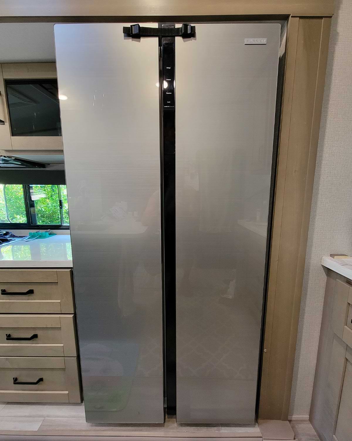 full front view of a RV refrigerator with a factory installed latch attached at the top of both doors