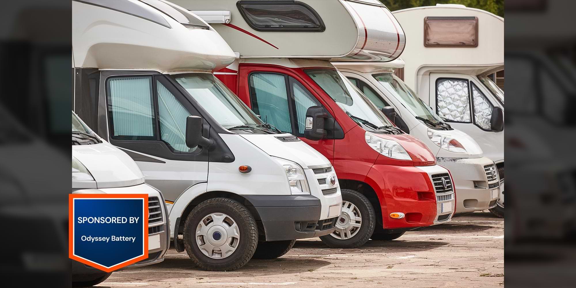 a line of RV van campers parked closely side by side