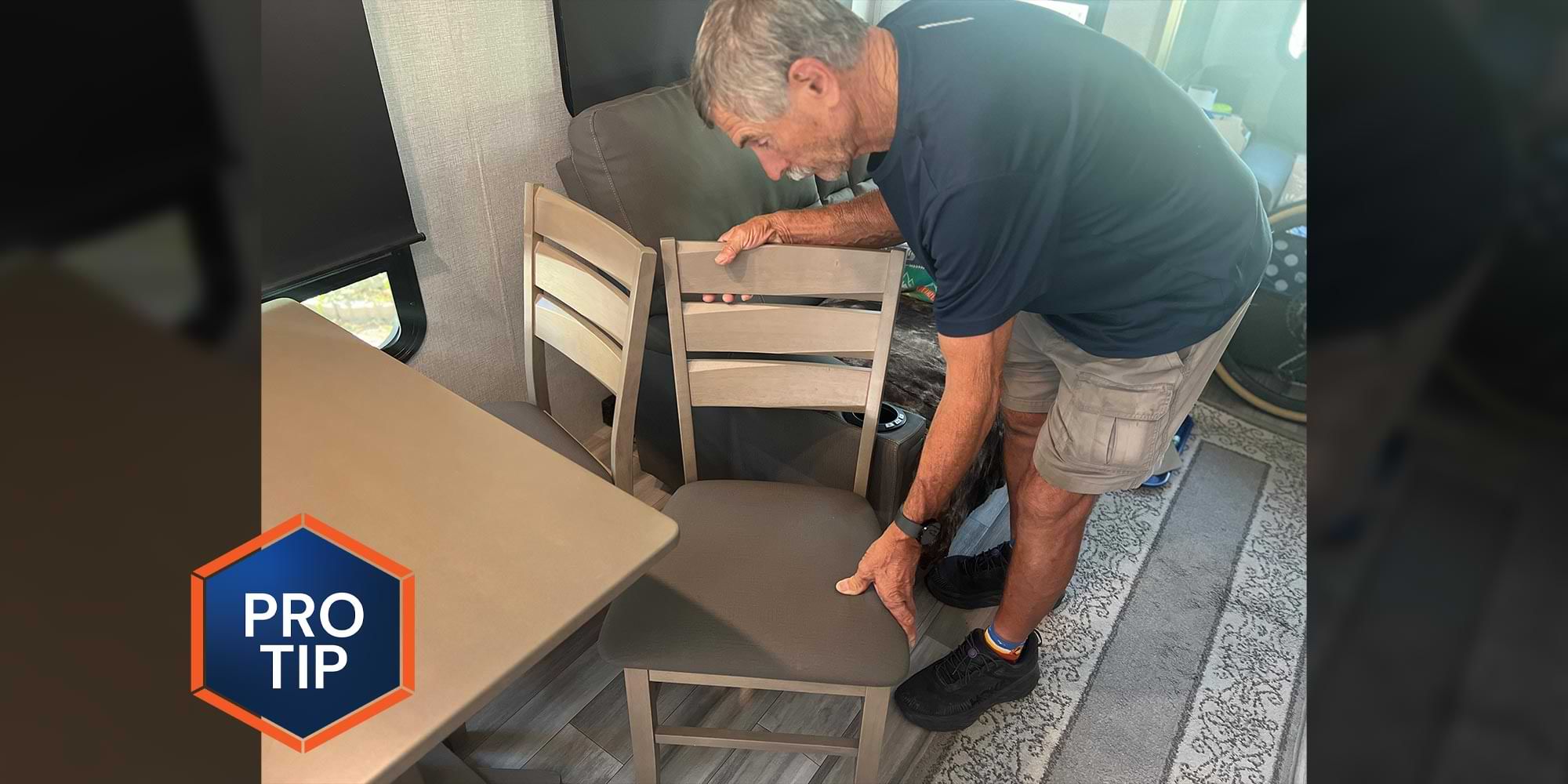 a man pushes an RV kitchen chair into its place under a table
