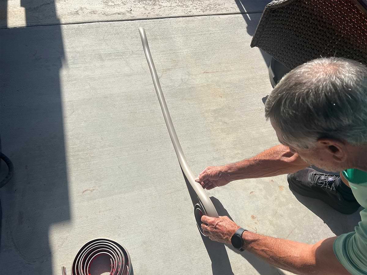 the PVC transition strip placed on a driveway in the sun to stretch out the rolled material