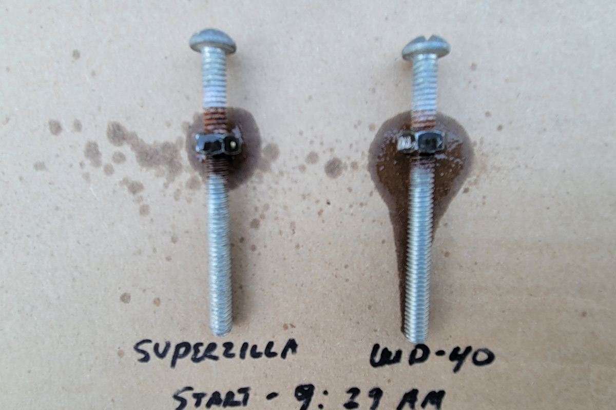 close view of a two rusted screws with nuts; one sprayed with Superzilla and the other sprayed with WD-40