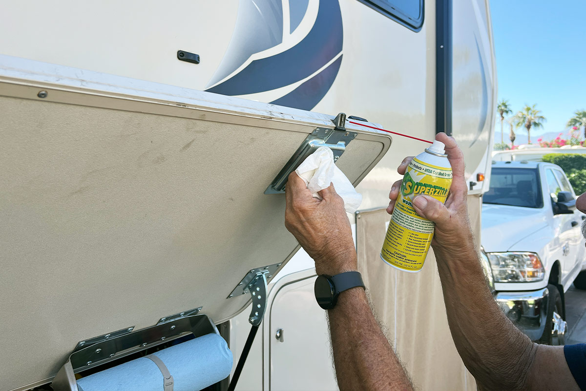 Superzilla is sprayed on the exterior compartment latch of an RV