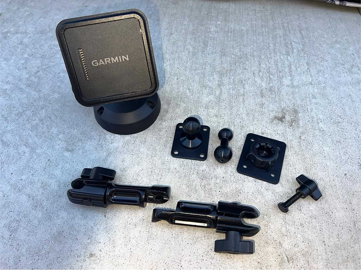 high angle view of the Garmin magnetic base parts organized including a Tackform 7-inch modular arm, a metal base with a 20mm ball for mounting the arm to the center console, a 20mm-to-17mm ball that connects to the top of the arm and an adapter