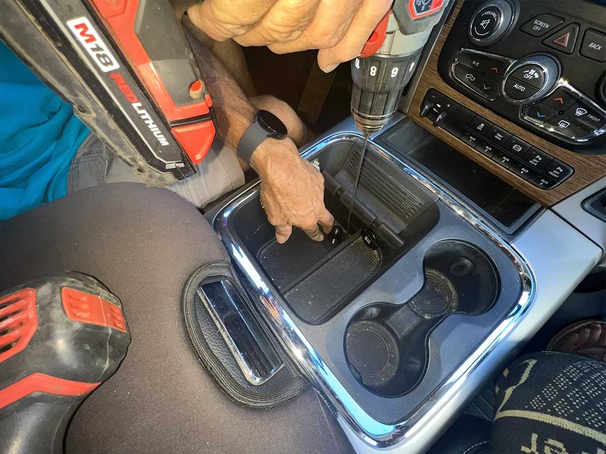 a drill is used to put the first pilot hole in the plastic center console