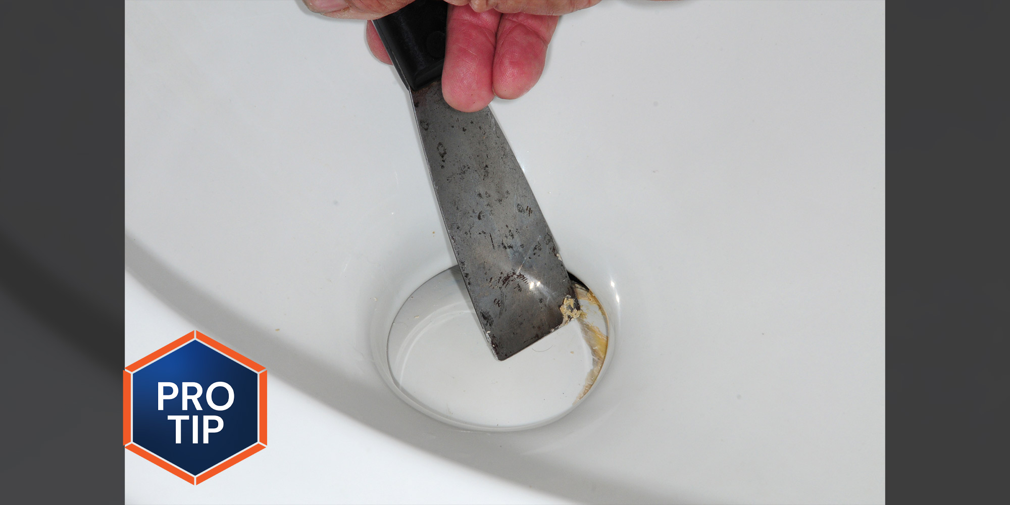 a putty knife is used to scrape a seal residue from an RV toilet valve