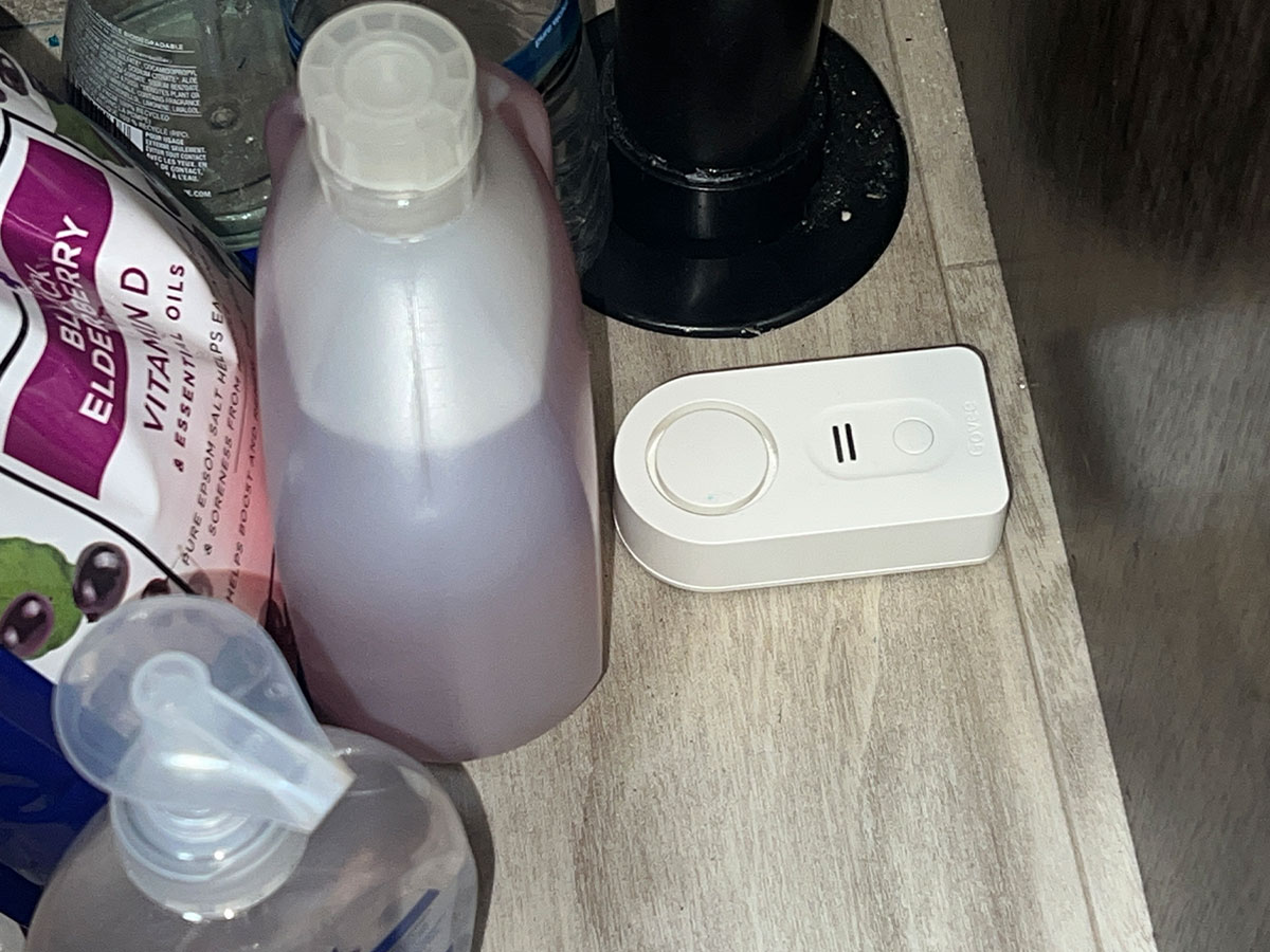 close view of a Govee water alarm sensor placed under the bathroom sink