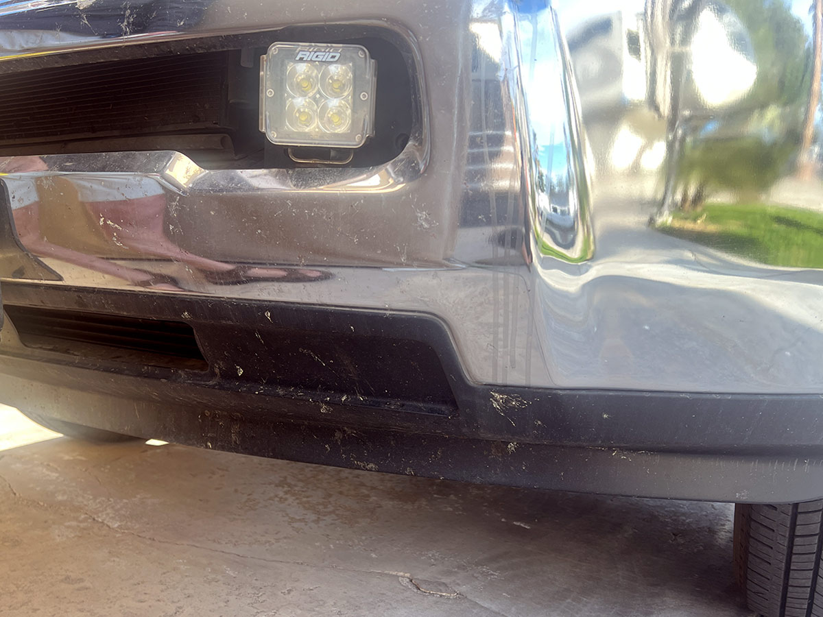 close view of the front bumper of a heavy duty truck splattered with dead bug bits