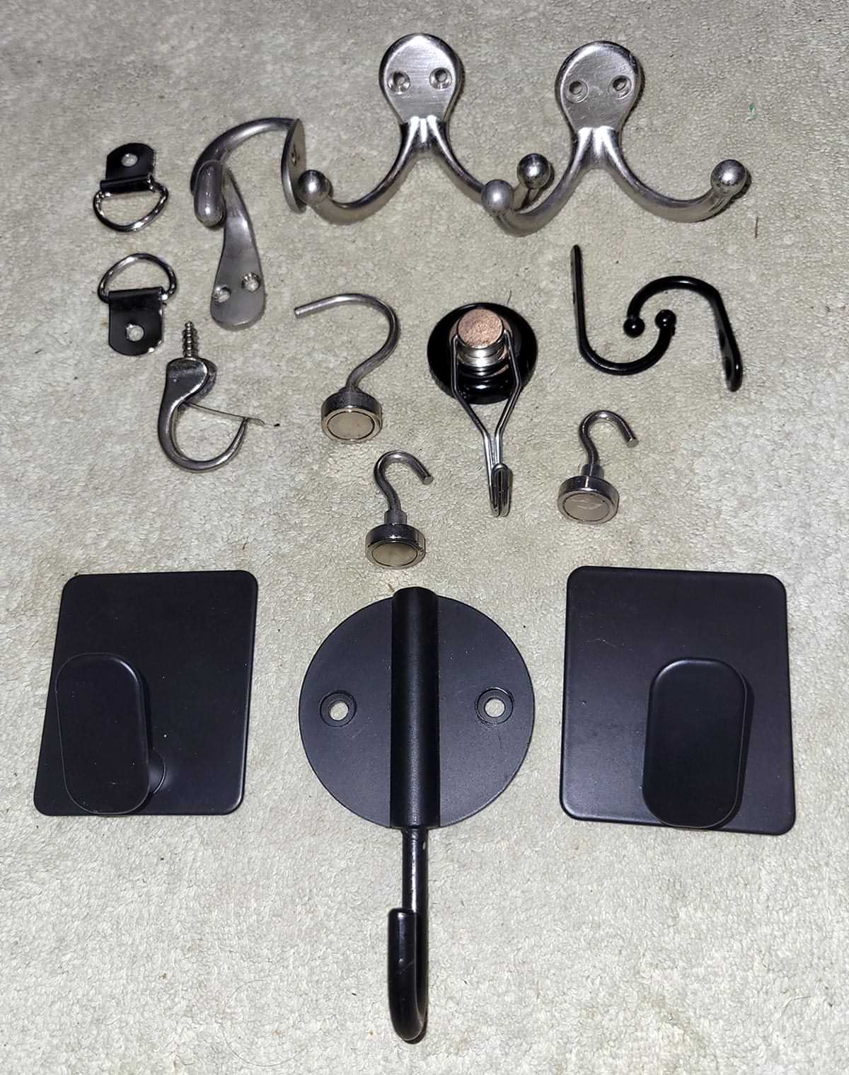 various hook types, including magnetic, adhesive and screw-in, placed on a surface