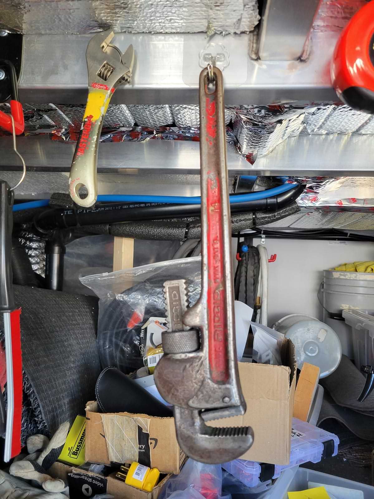 a JelKen hook holds a monkey wrench from an aluminum rafter in an RV external compartment