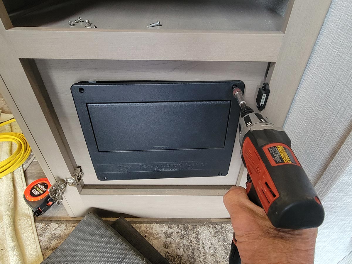 a drill gun is use to remove the four screws securing the distribution panel door