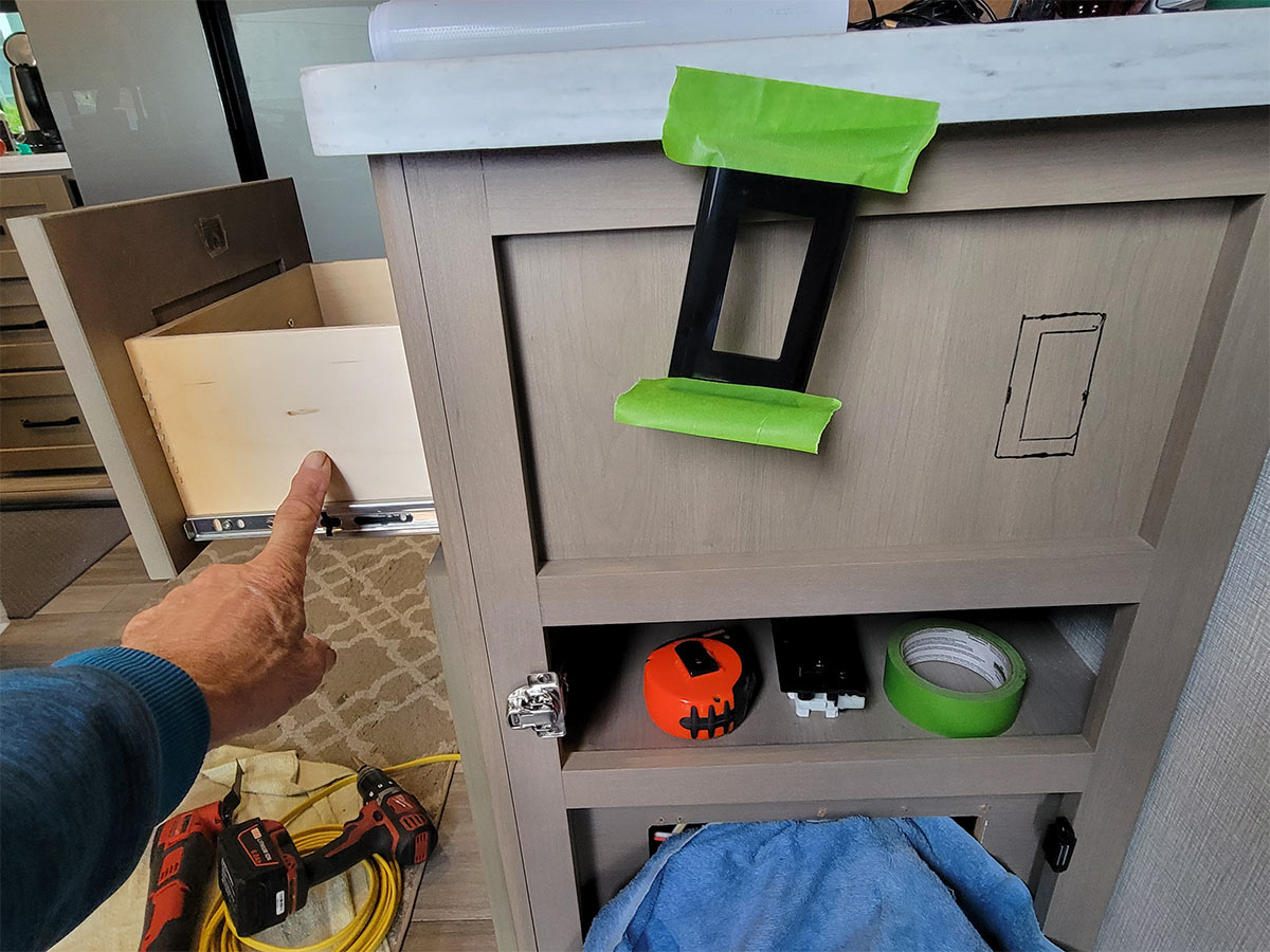 the one-piece RV-type 120-volt AC outlet is used at a guide for the trim hole on the cabinet side