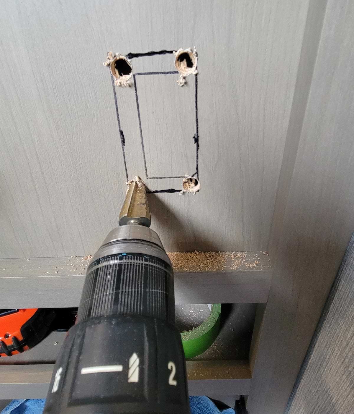 a step-bit is used to drill the four corners for the outlet installation