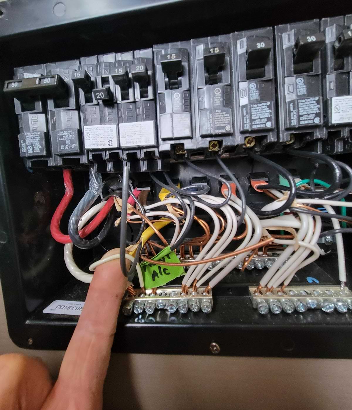 a finger points to a wire in the breaker