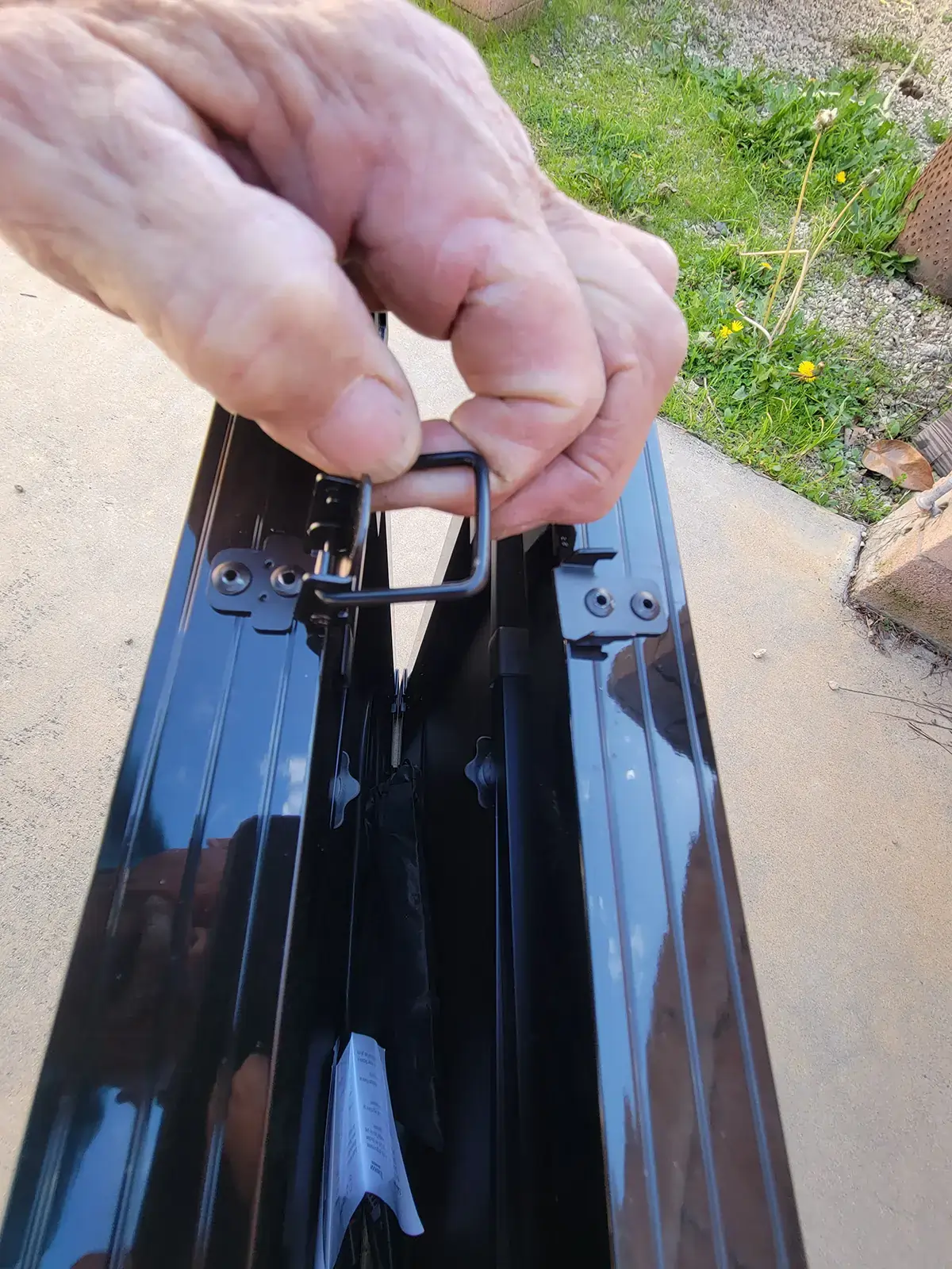 a hand releases one of the latches on the Renogy 100-watt foldable suitcase solar panel kit