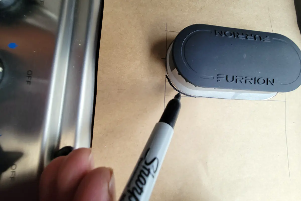 close view of a Sharpie marking a central hole for further trimming