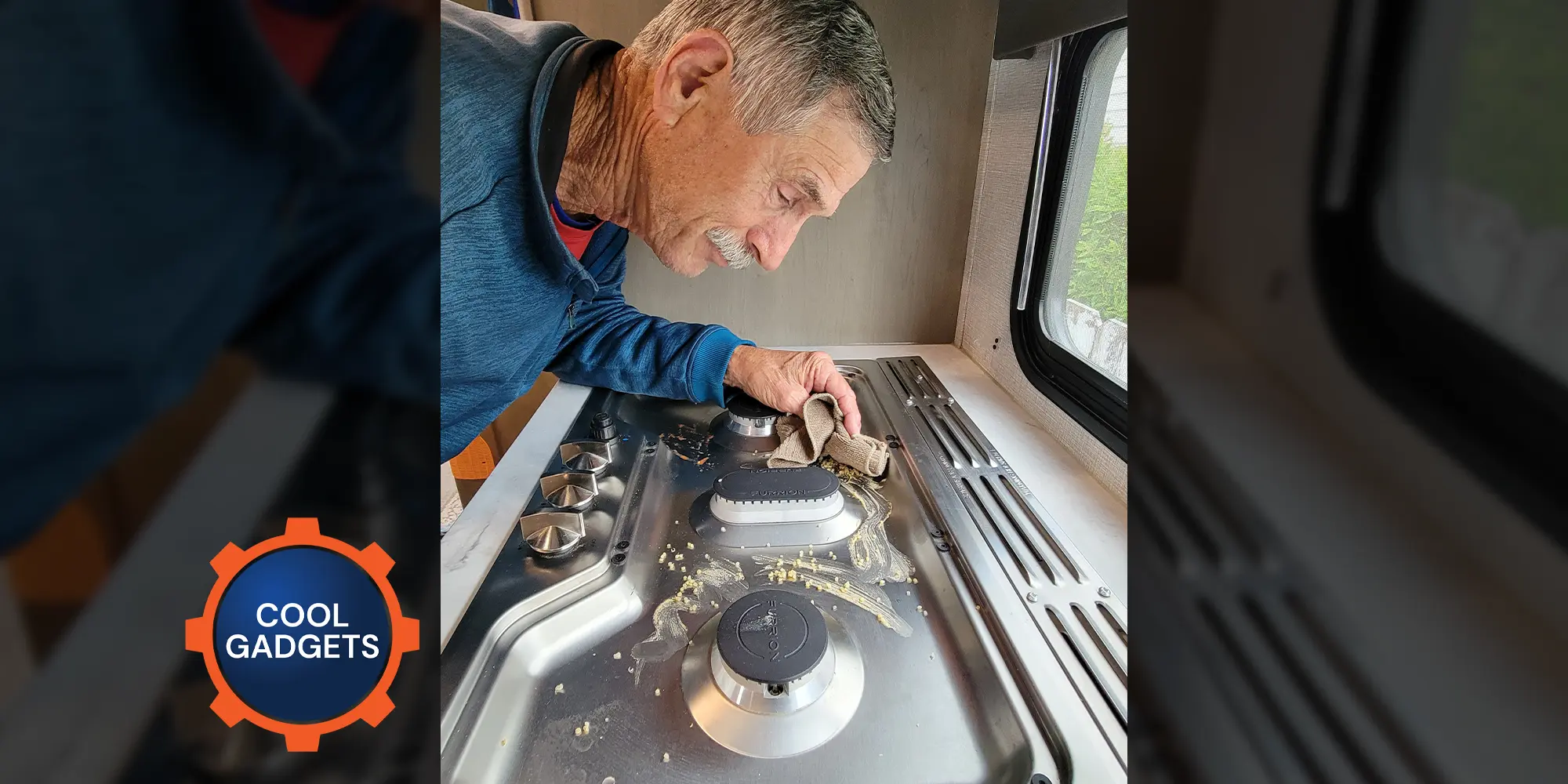 a man leans in close to clean a foodstuff mess on an RV cooktop