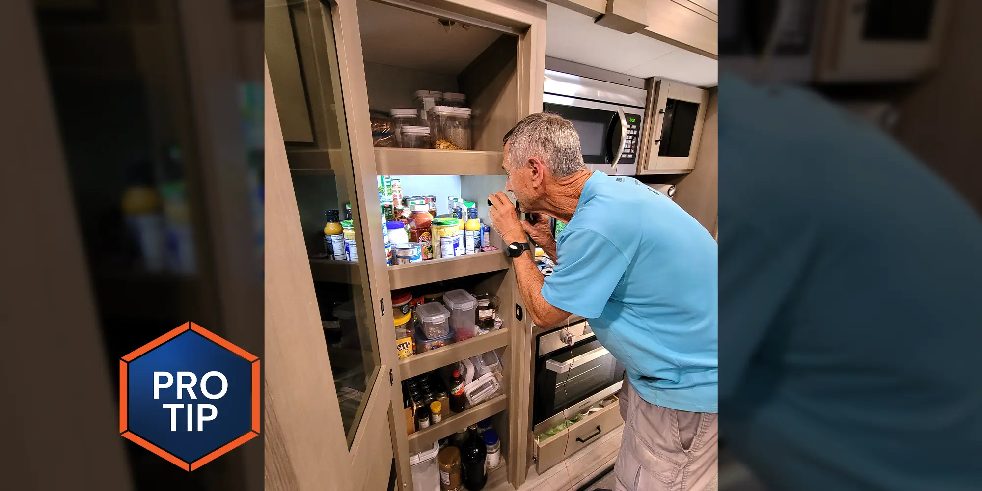 a man uses a small flashlight to search one of five packed shelves in an RV pantry