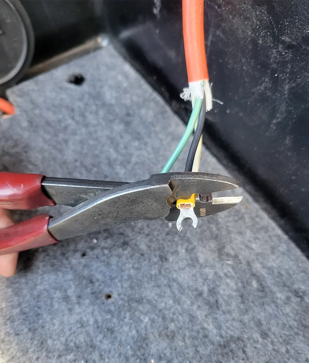 close view of a plier wrench being used to adjust an extension cord wire