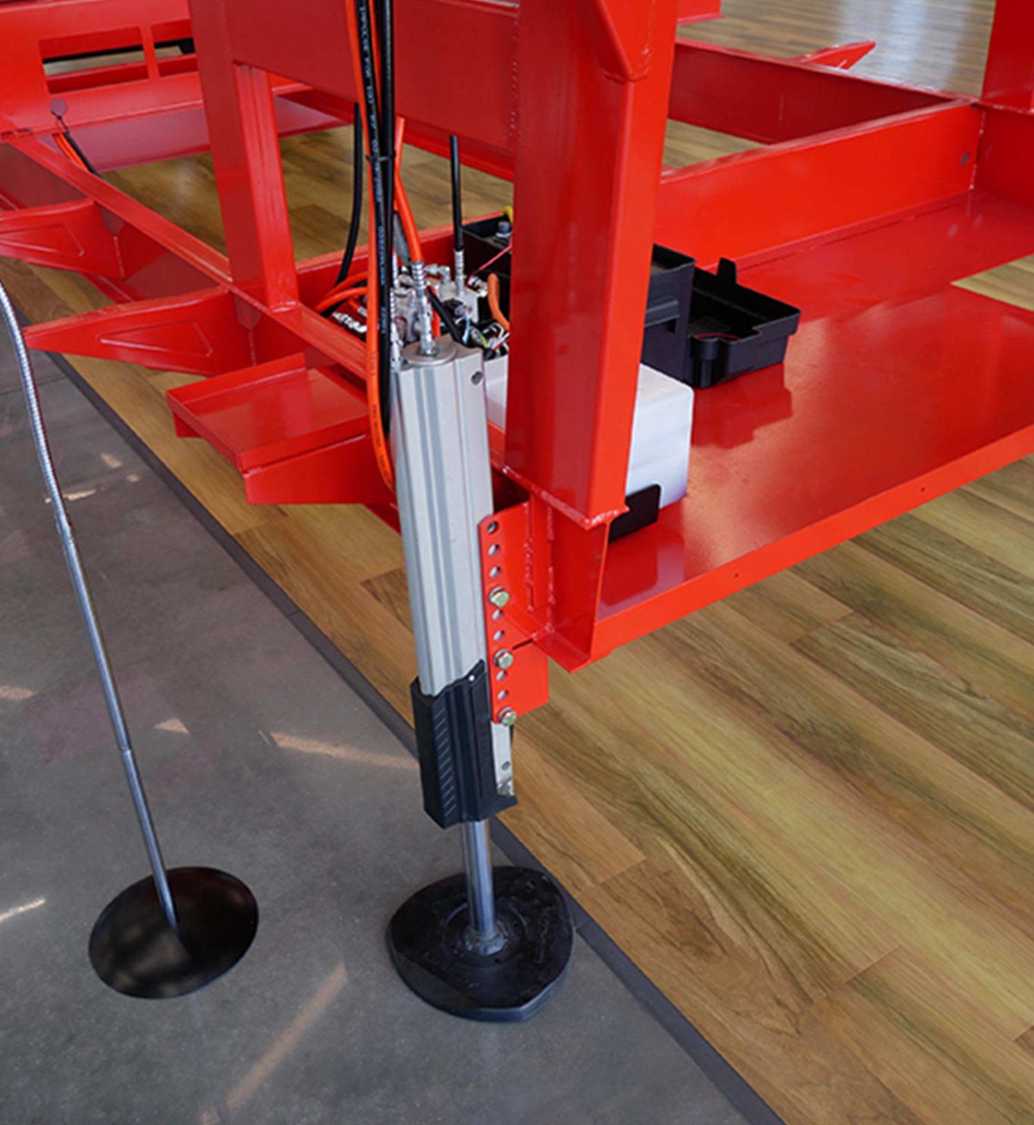 a leg featuring Lippert’s attractive and simplified new leveling system attached to a bright red chassis