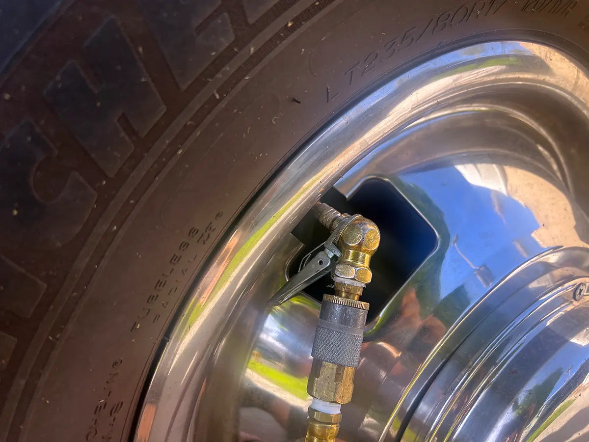 a clip-on air chuck attached to a Gator Cap on a tire