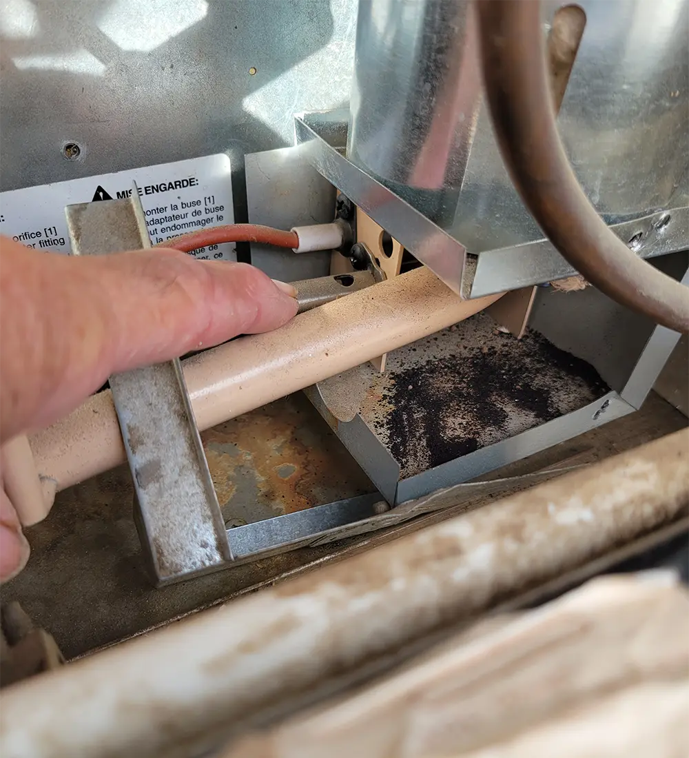 an index finger points to a tight area within an RVs components that holds dirt and debris
