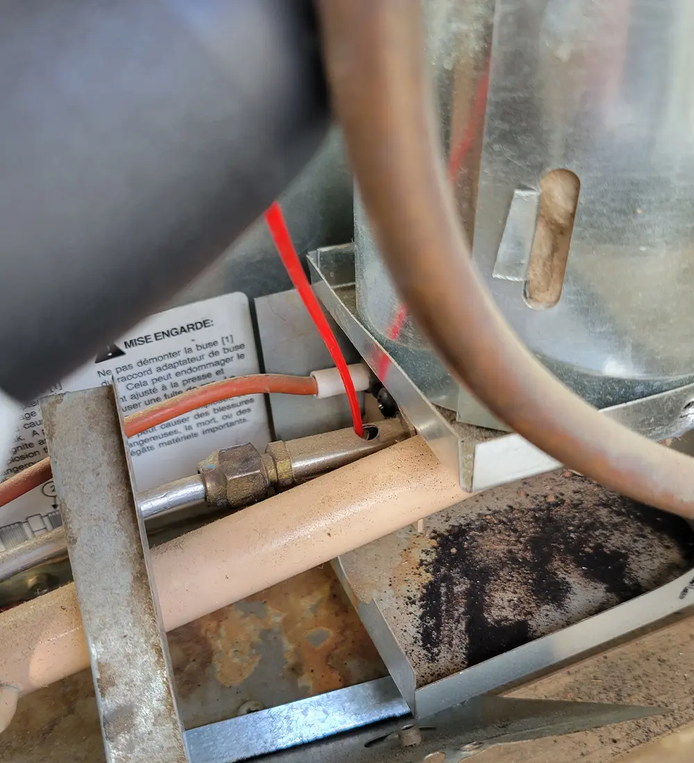 cropped view of the red straw of the Falcon Dust-Off Electronic Duster container placed into an RV's burner tube