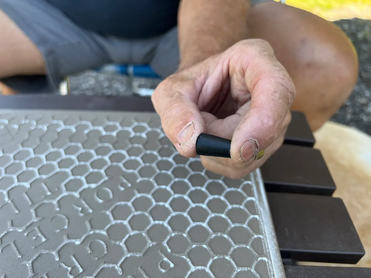 close view of a hand holding a black rubber stopper