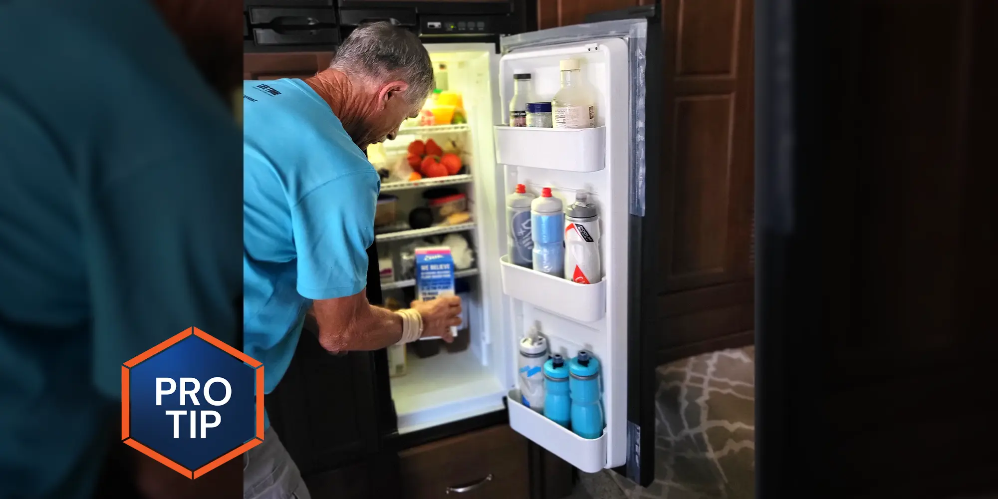 a man places a carton into an RV refrigerator with a door seal that has replaced areas