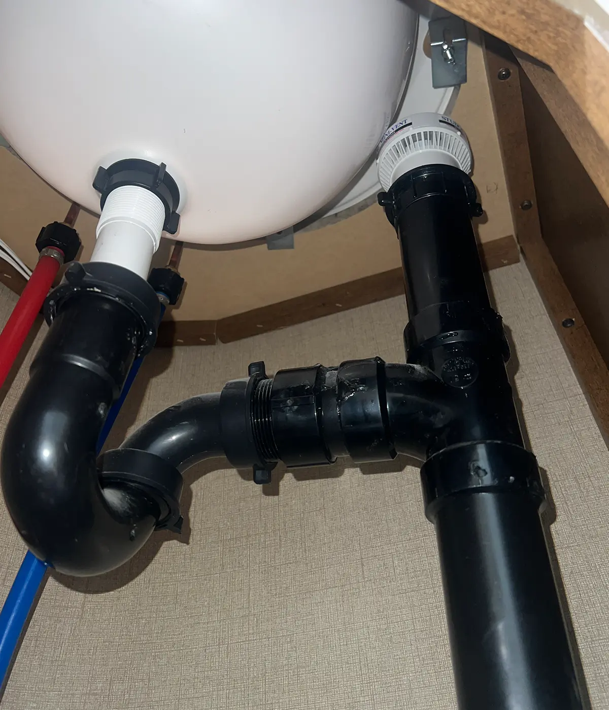 view upward from the base of the bathroom sink piping at the tight clearance of the installed Studor Mini-Vent