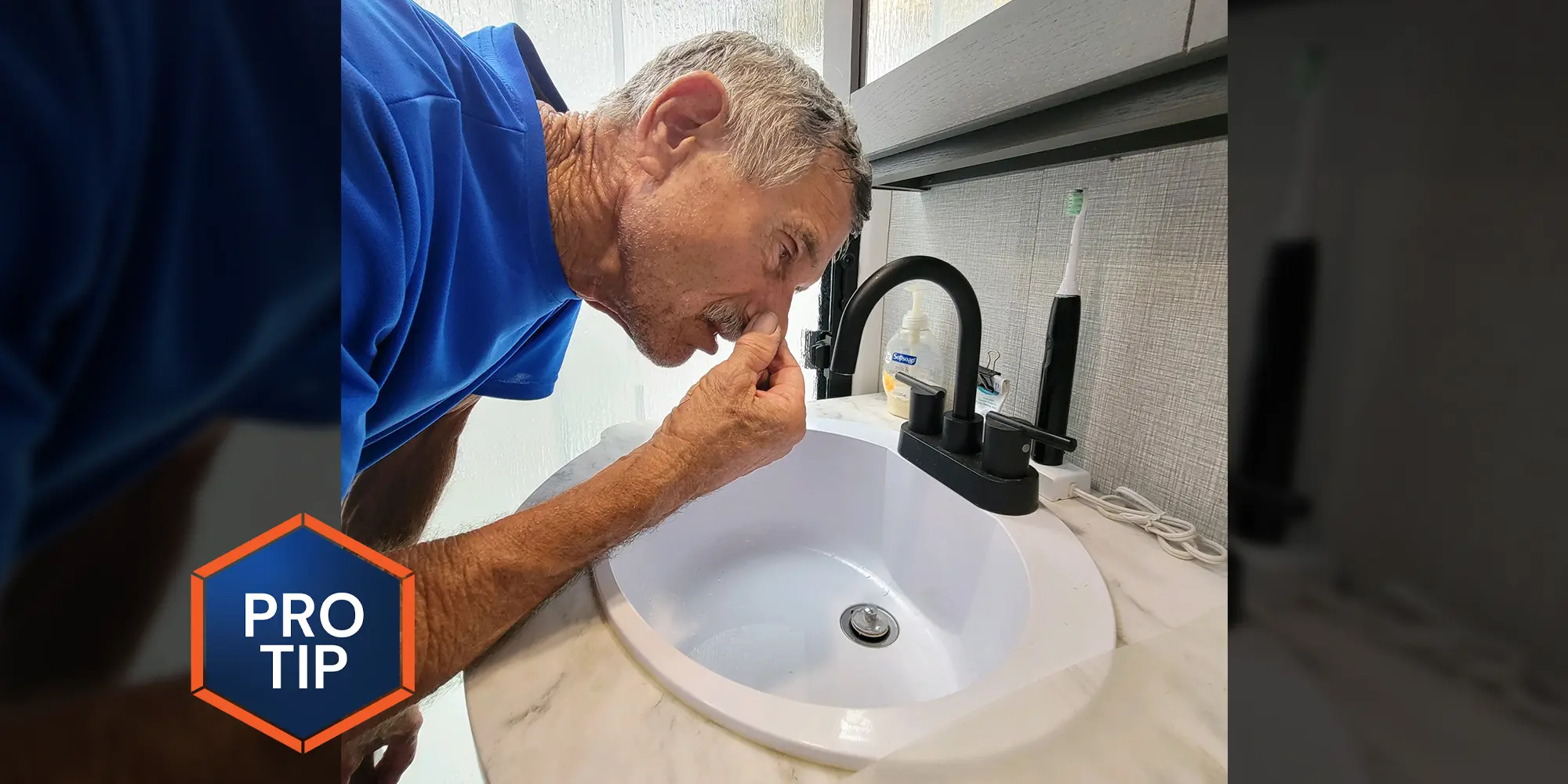 a man leans close in to an RV bathroom sink while pinching his nose