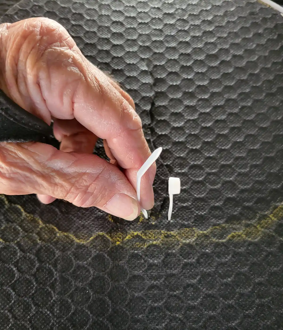 the first zip tie is threaded through the first two holes in the Coroplast material