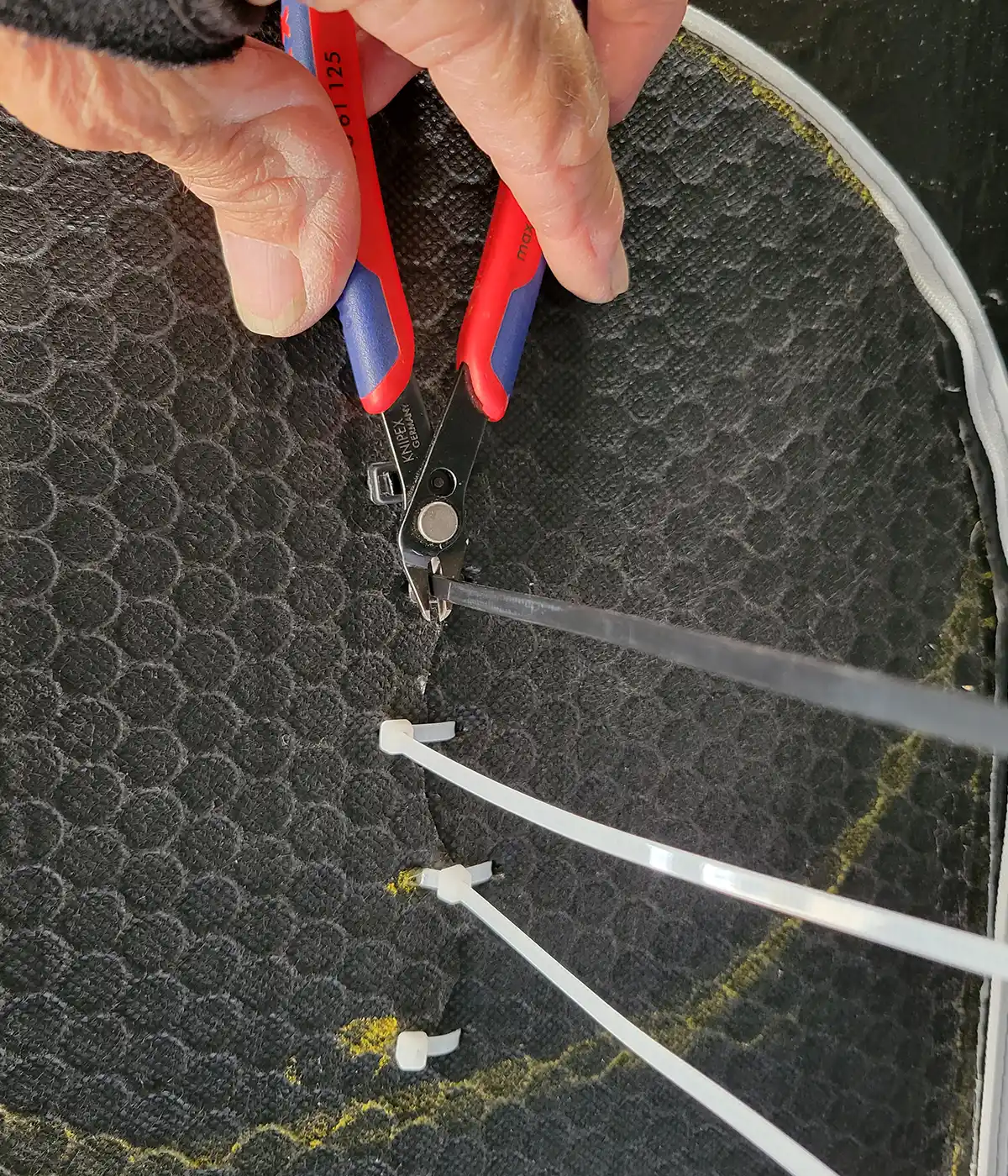 close up of the zip tie tails being trimmed close to the locking head