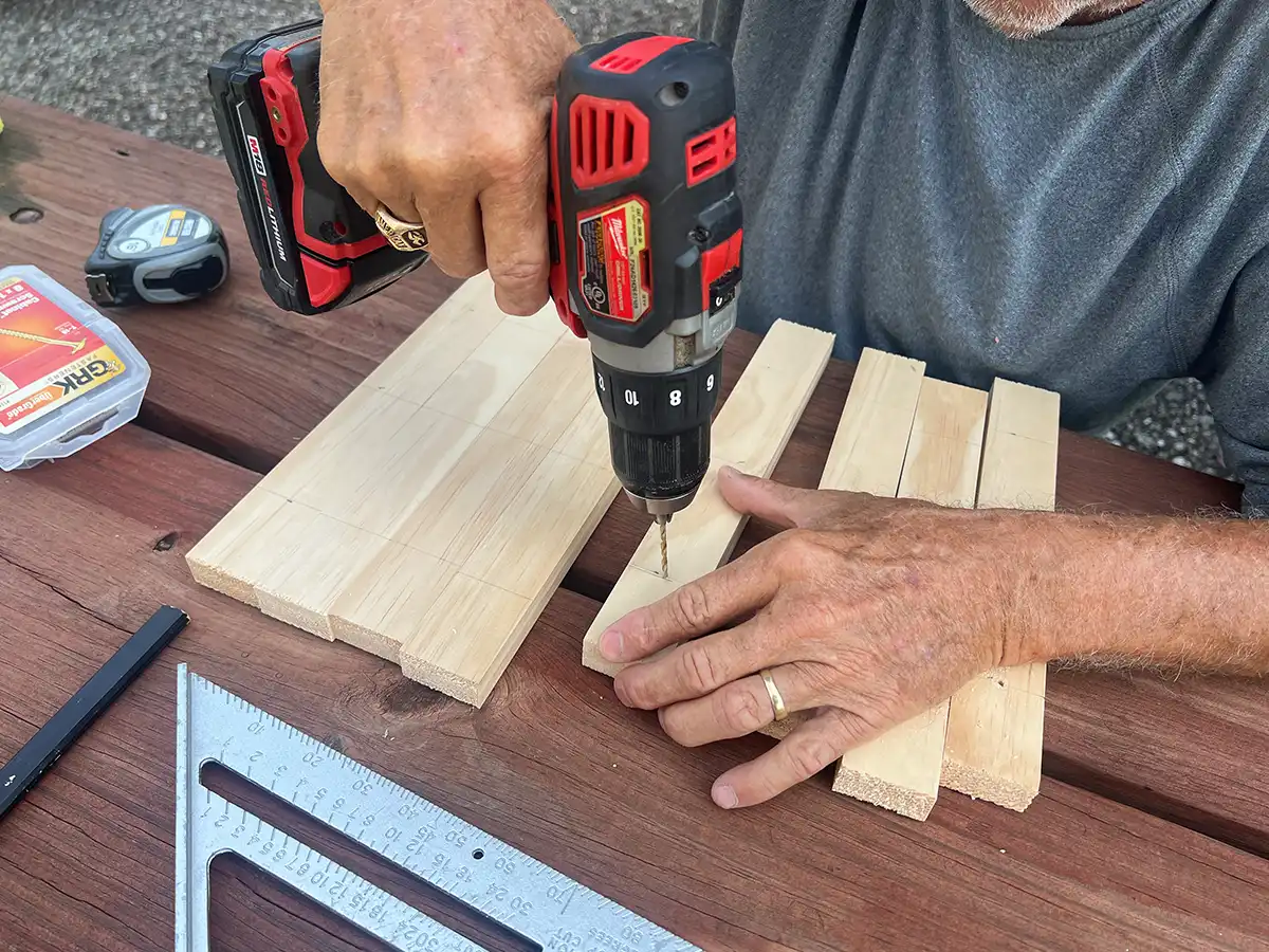 one of three 7/64-inch pilot holes is drilled into on of the pieces of pine board