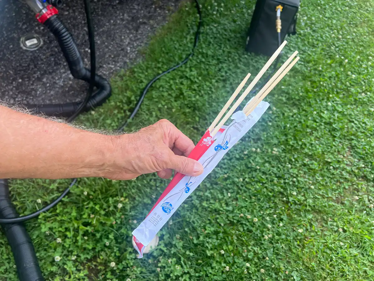 a hand holds to opened packages of bamboo chopsticks