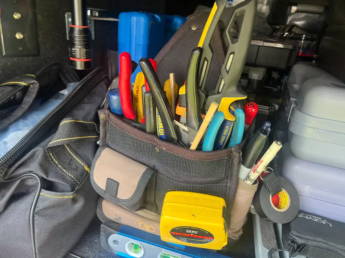 full view of a tool bag packed with tools including two chopsticks